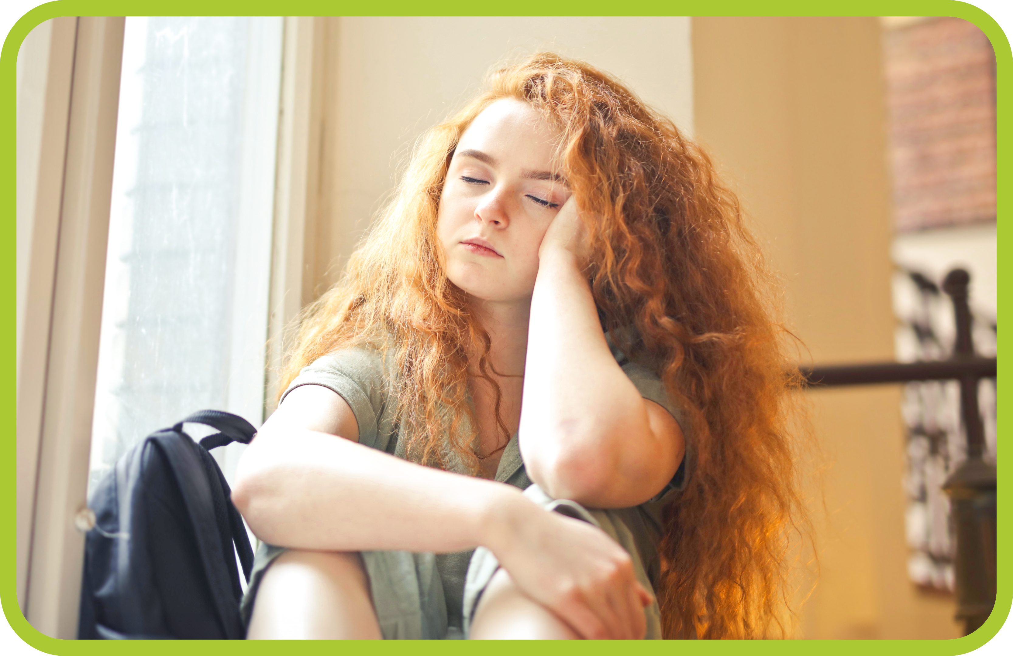 Young girl with head on hand looking sad.