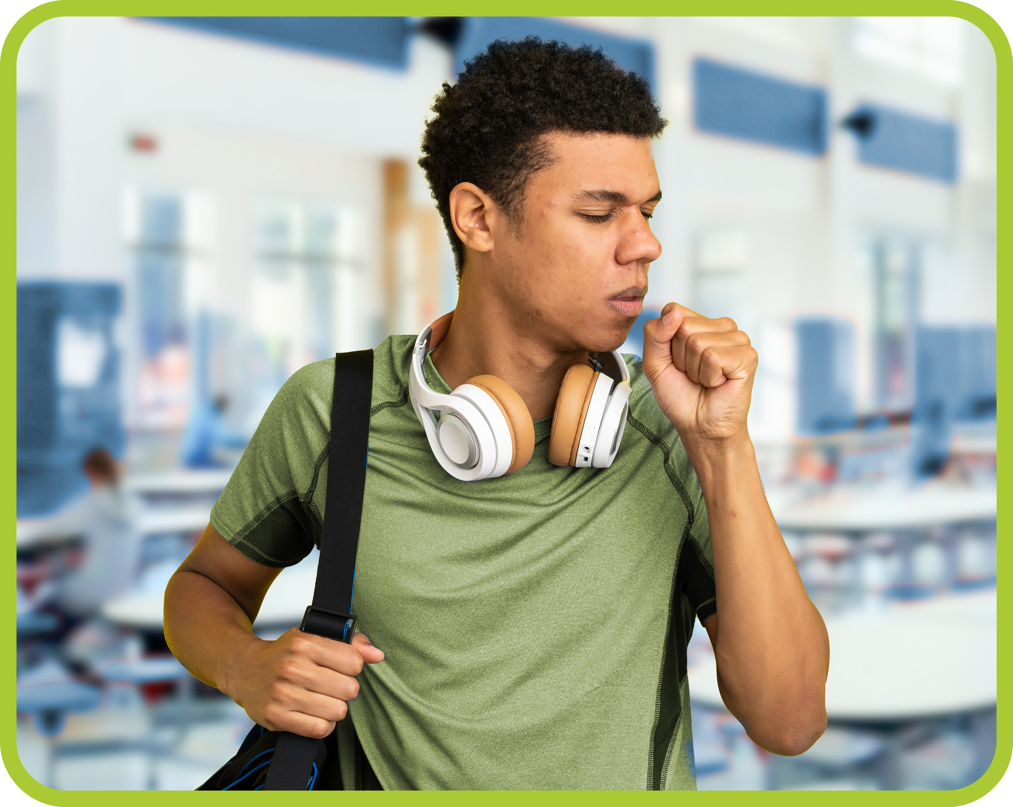 Young boy with headphones coughing into hand.